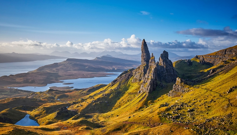 View Over Old Man Of Storr, Isle Of Skye, Scotland. During a beautiful sunrise and dramatic sky with a local shower here and there. The Old Man of Storr looms over Portree, Isle of Skye and is situated 7 miles north of the town. It is dominated by the 50 metre high petrified lava pinnacle of the Old Man of Storr, with a brutal tumble of cliff behind, and the panorama spreads across loch, sea and islands to the high mountains of the mainland beyond.