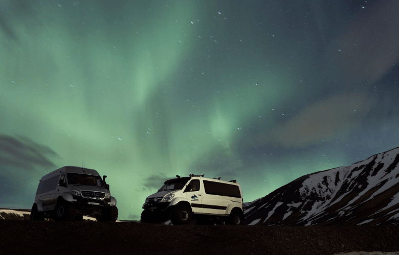Cars in front of the Aurora Borealis